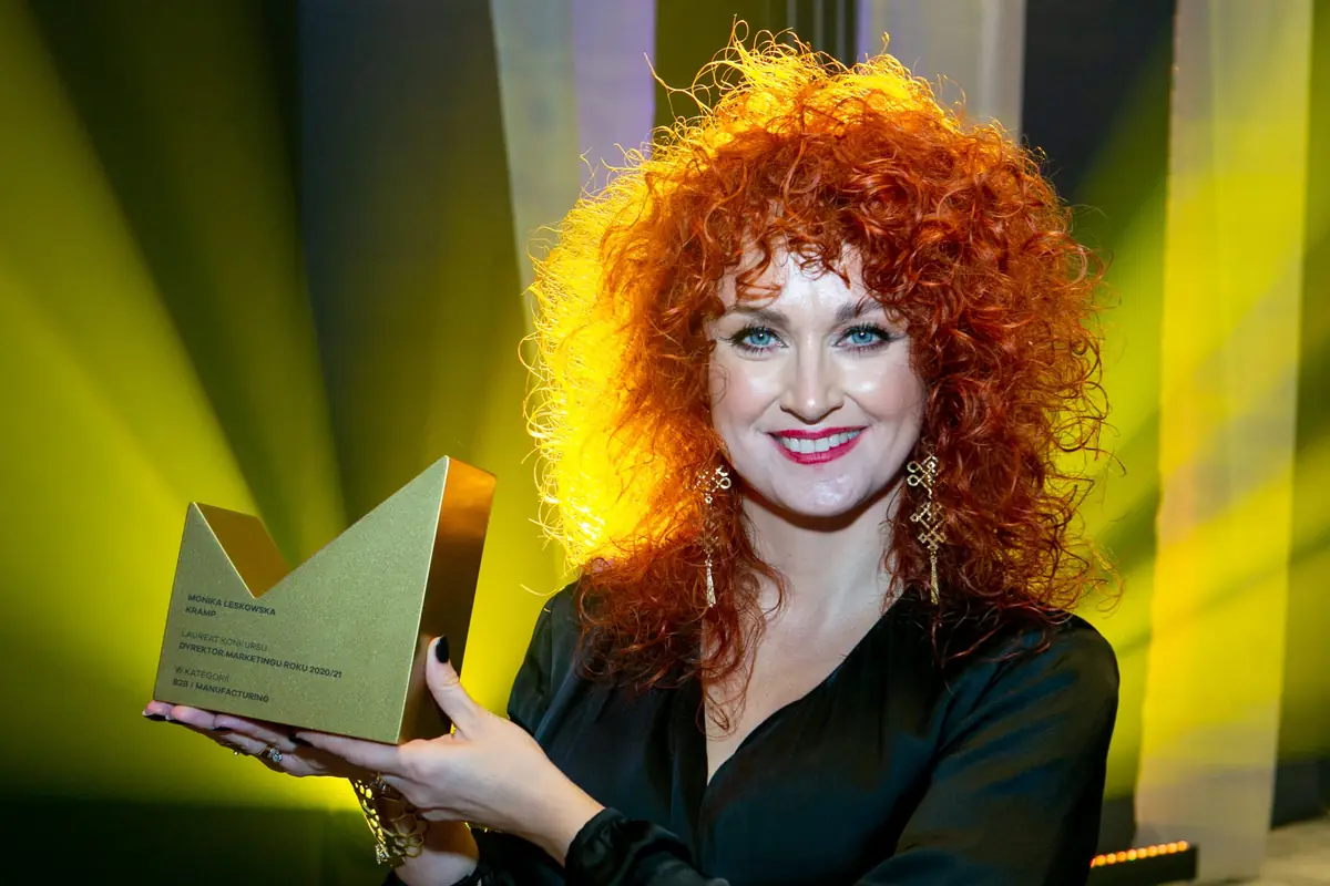 A winner raises the statuette in golden light