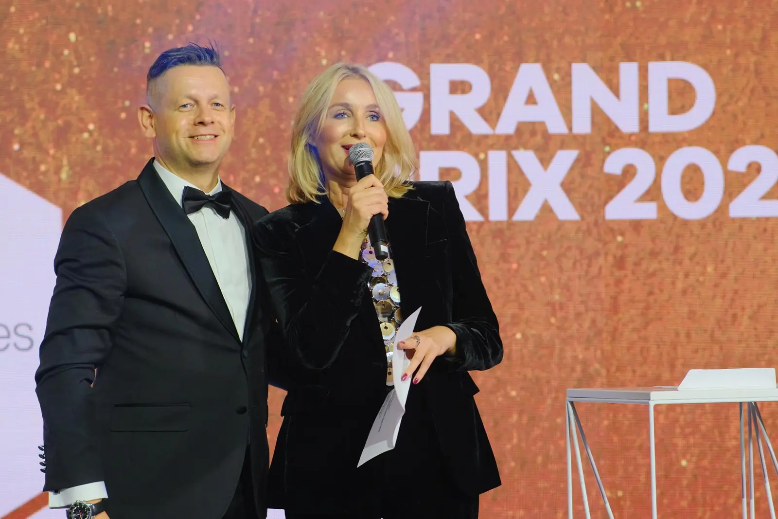 The hosts announce the Grand Prix on the Gala stage