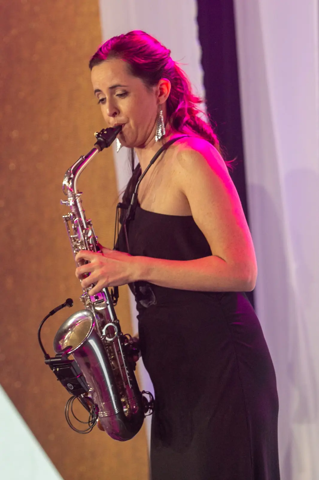 Saxophonist in a dark gown plays a solo in pink spotlight — DMR Gala X (2021)