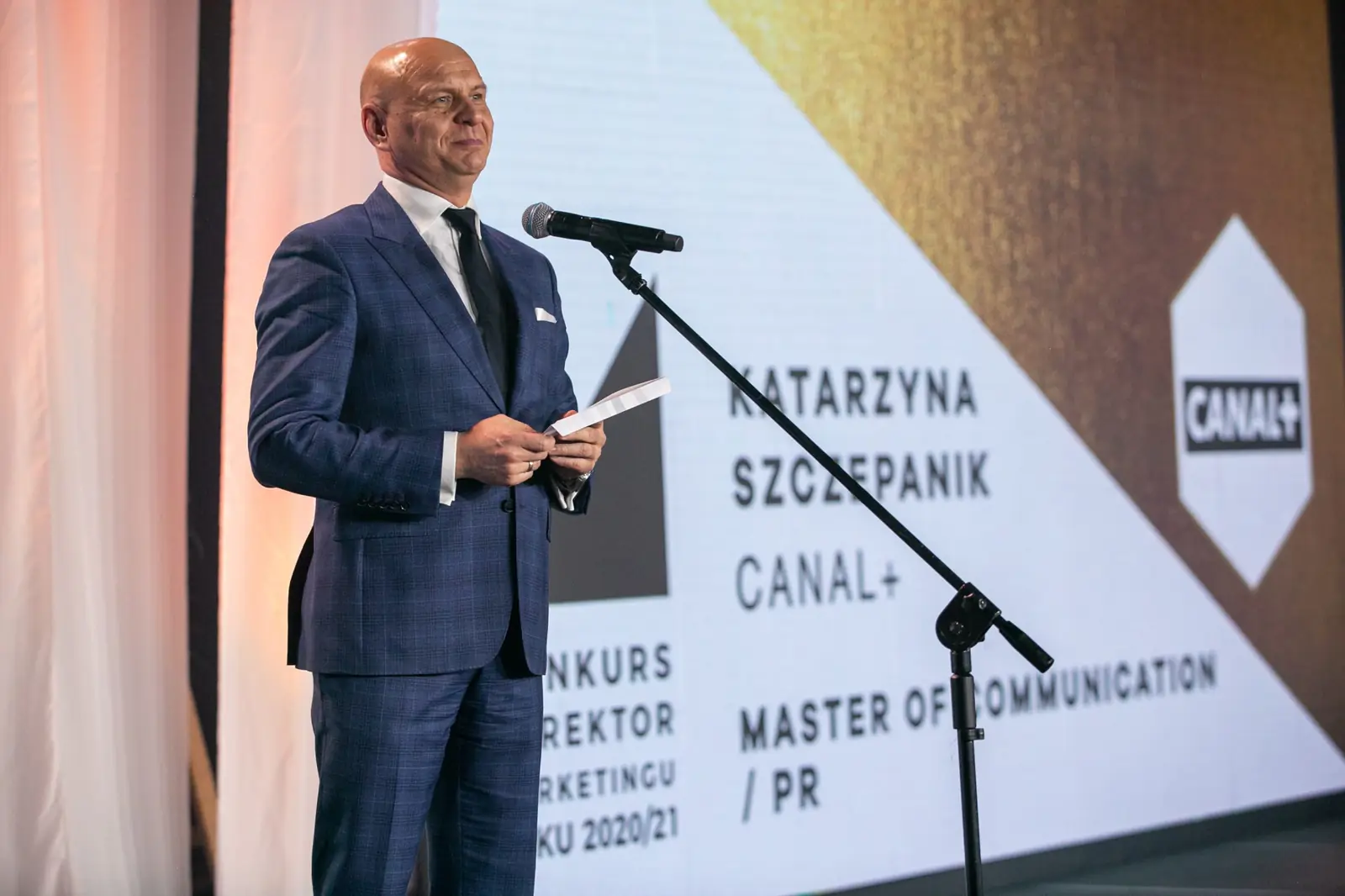 Presenter in a navy suit announces the Master of Communication and PR category — DMR Gala X (2021)