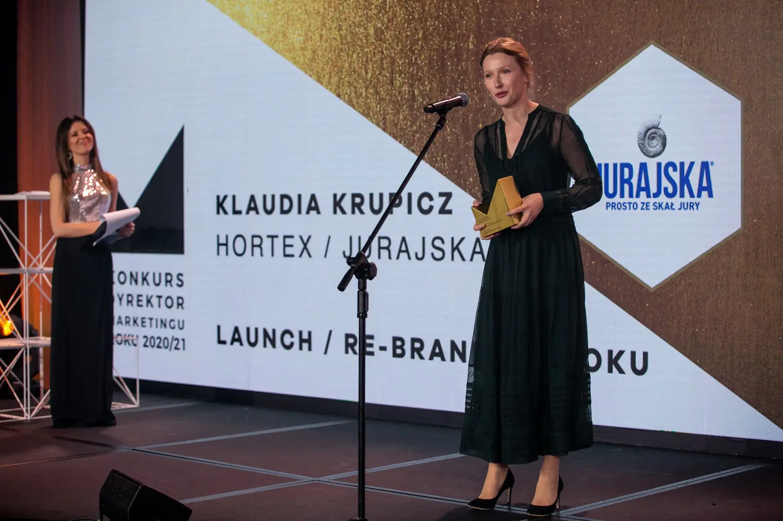 Szeroki kadr: laureatka w kategorii Launch / Re-brand Roku przemawia przy mikrofonie — Gala DMR X (2021)