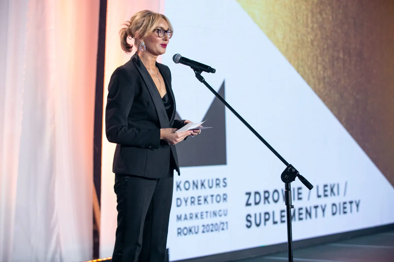 Presenter in a black suit announces the health, medicines and dietary supplements category — DMR Gala X (2021)