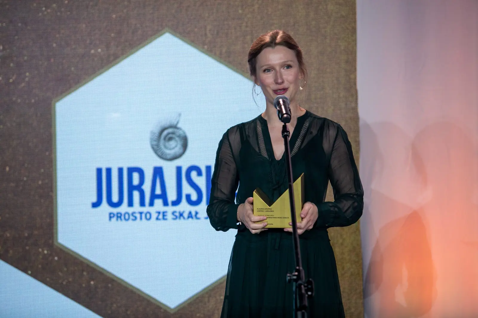 Laureatka w kategorii napoje i alkohol przemawia przy mikrofonie ze statuetką — Gala DMR X (2021)