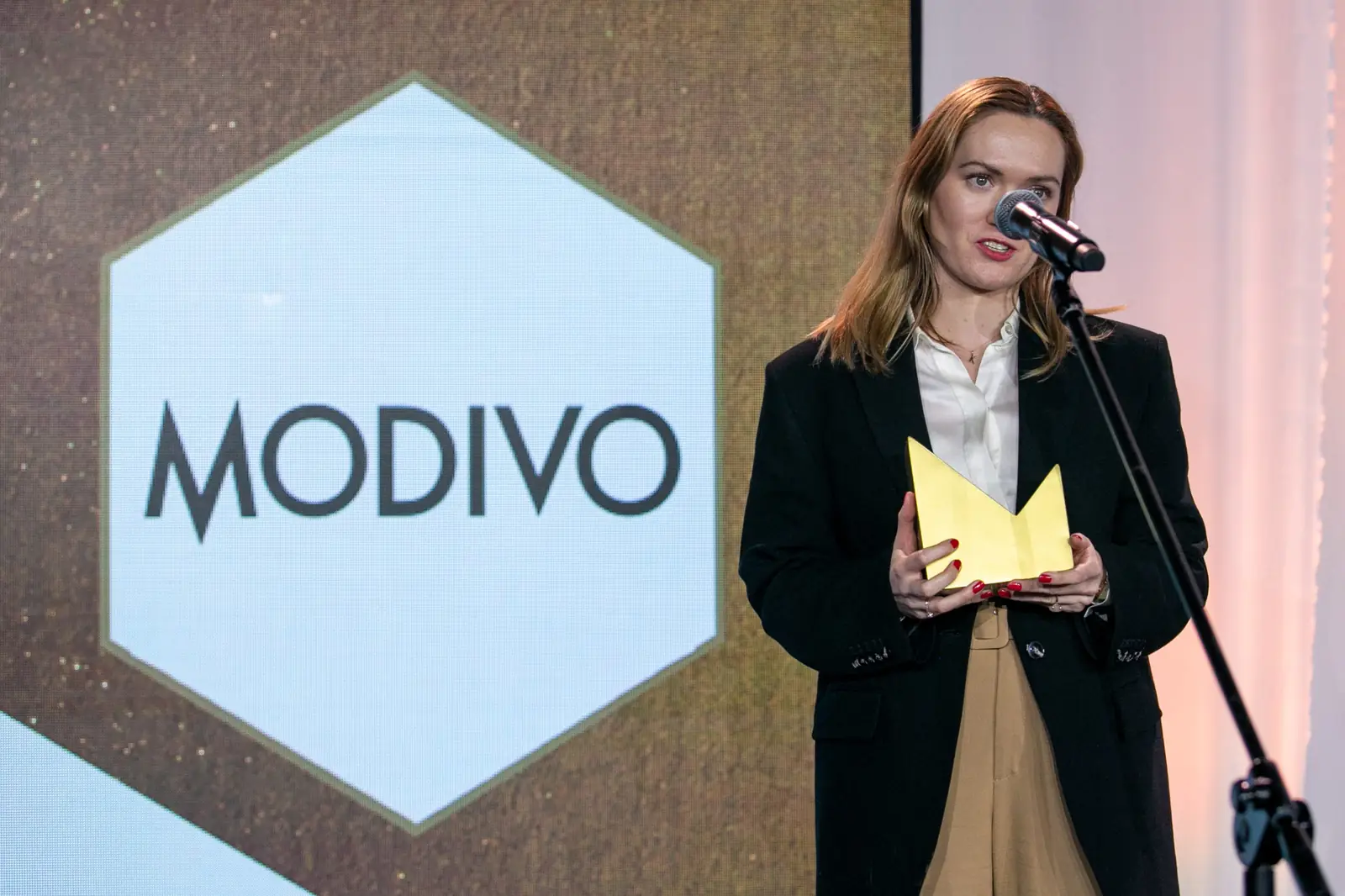 Laureatka kategorii e-commerce w czarnej marynarce dziękuje za nagrodę przy mikrofonie — Gala DMR X (2021)