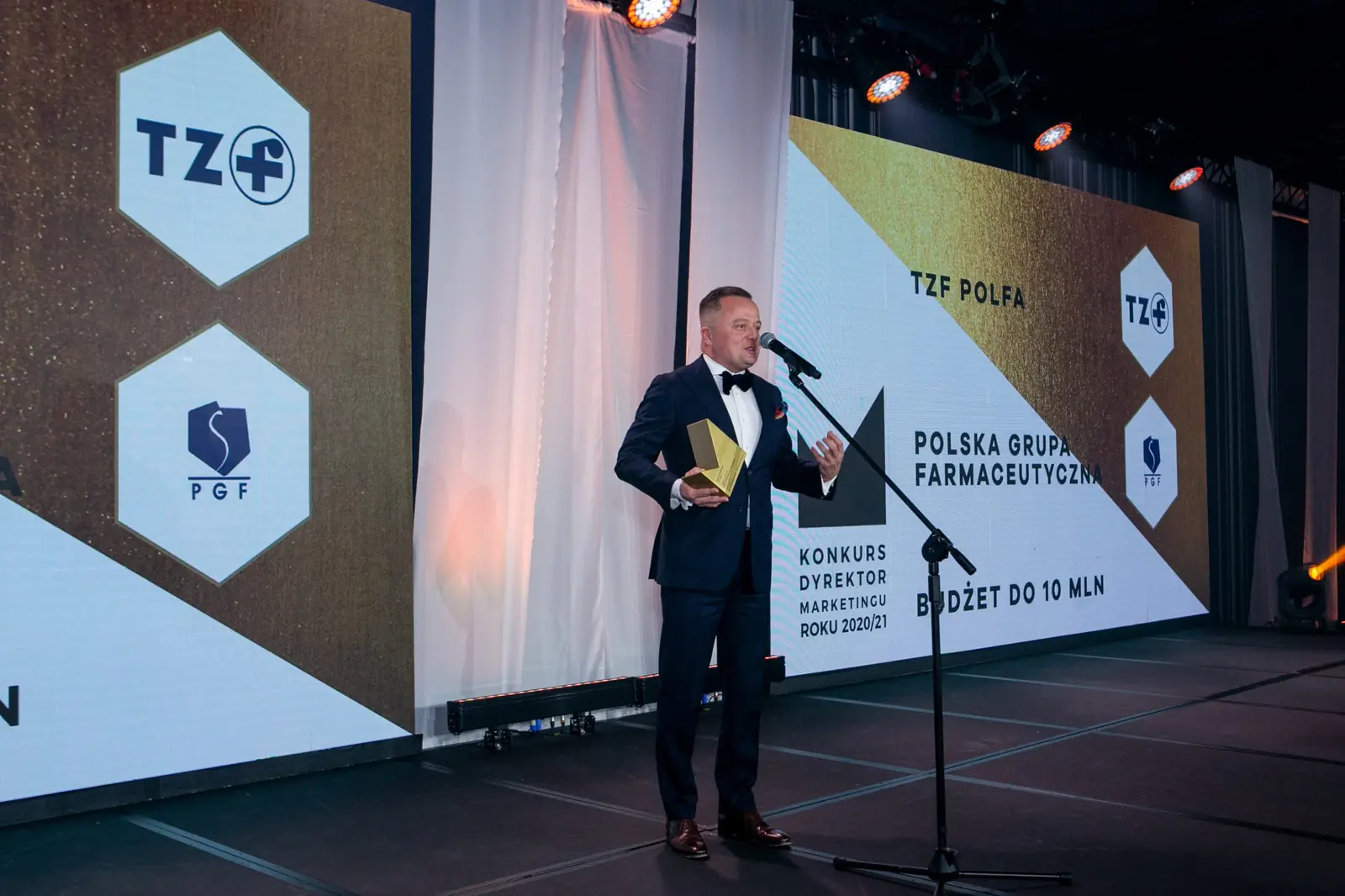Szeroki kadr sceny: laureat w kategorii budżet do 10 mln przemawia przy mikrofonie — Gala DMR X (2021)