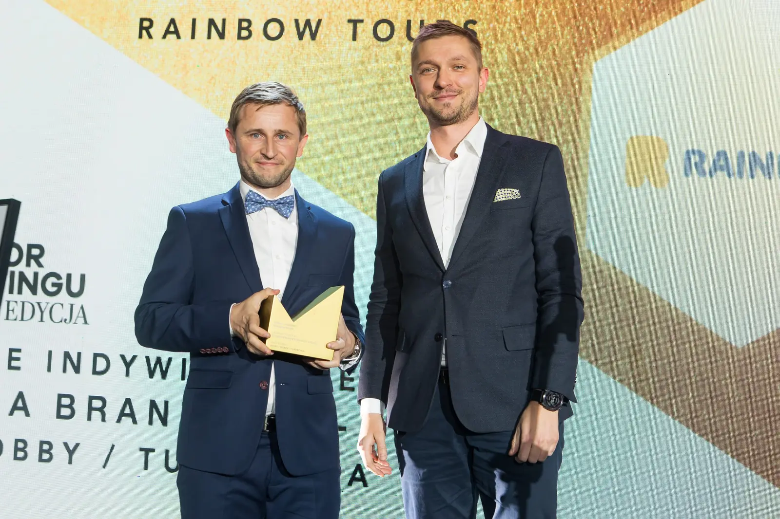 Laureat w muszce i wręczający pozują ze złotą statuetką w kategorii hobby i turystyka — Gala DMR XI (2022)