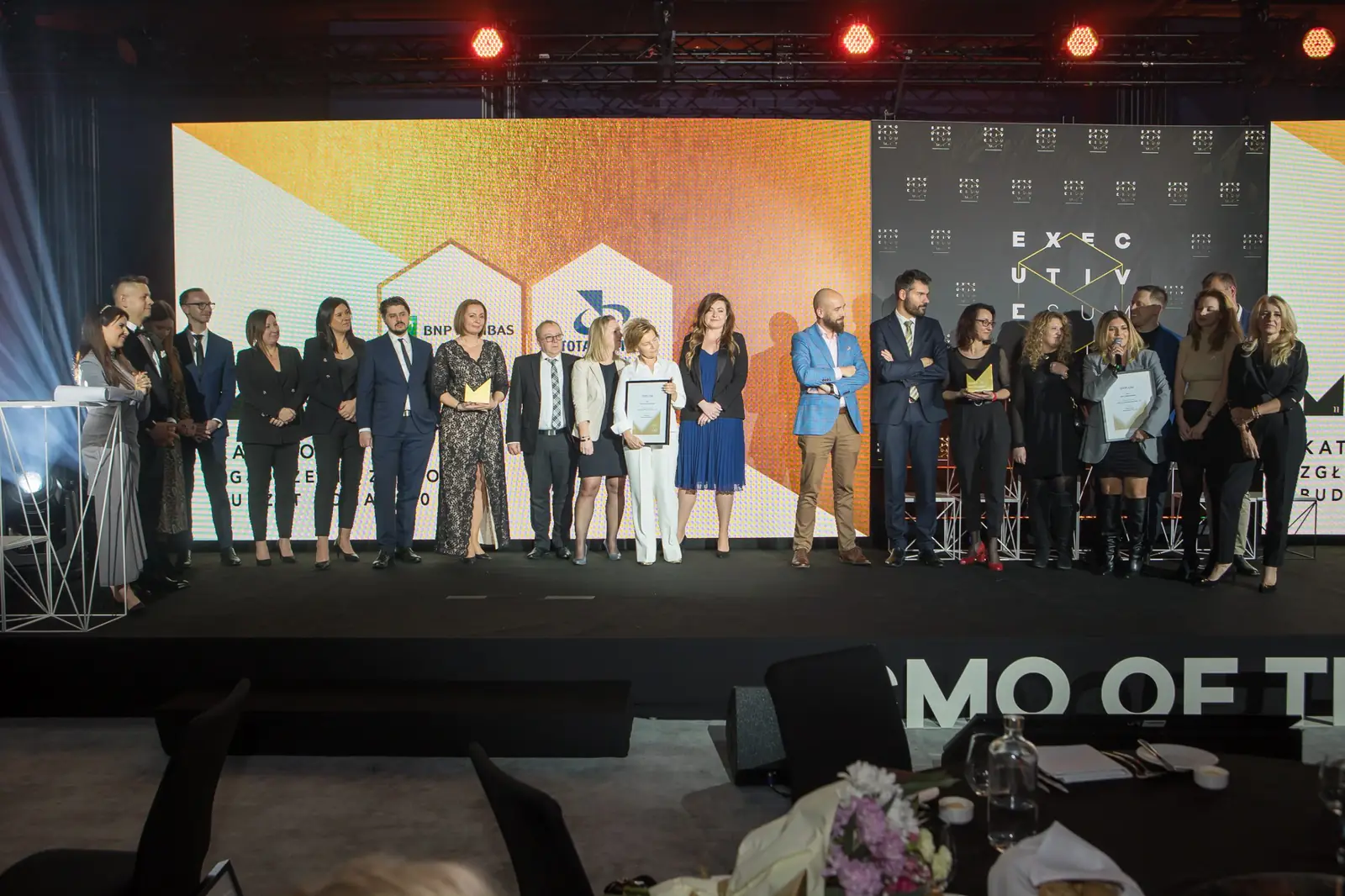 Długi szereg nagrodzonych zespołów na scenie, na pierwszym planie stoliki z kwiatami — Gala DMR XI (2022)