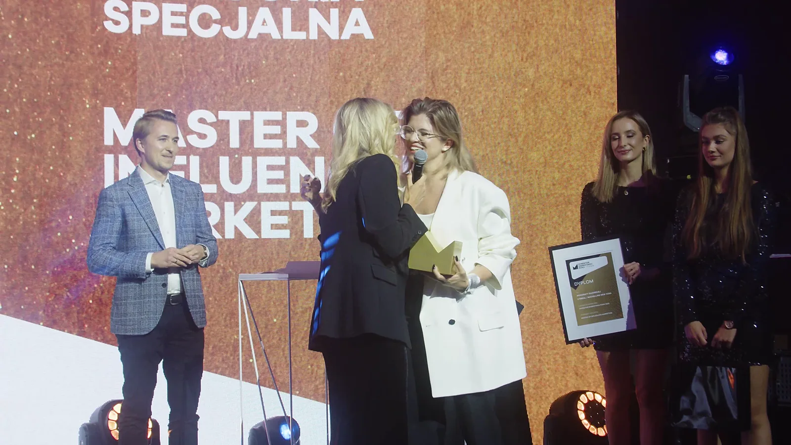 Laureatka nagrody za influencer marketing w białej marynarce obejmuje blondynkę w czerni — Gala DMR XII (2023)